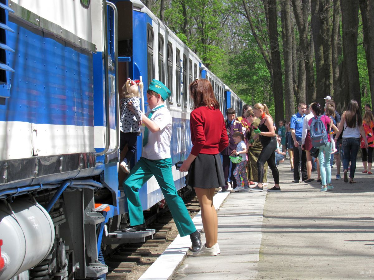 Проводник помогает юной пассажирке при посадке в поезд