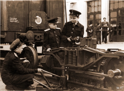 Юные железнодорожники ремонтируют тележки вагона