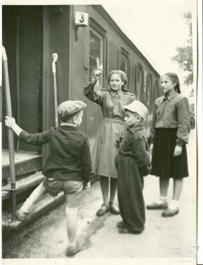 Юные железнодорожники и пассажиры у вагона, проверка билета.